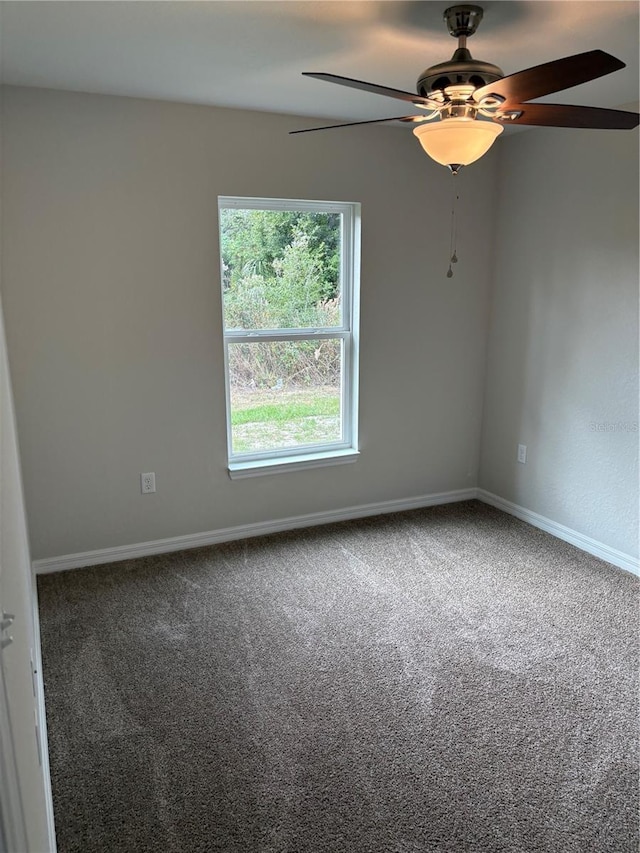 carpeted spare room with ceiling fan and baseboards