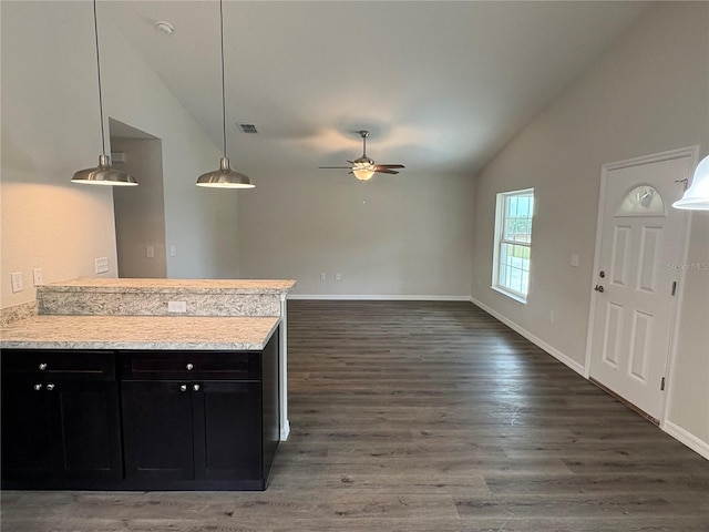 kitchen featuring a peninsula, wood finished floors, vaulted ceiling, light countertops, and dark cabinetry