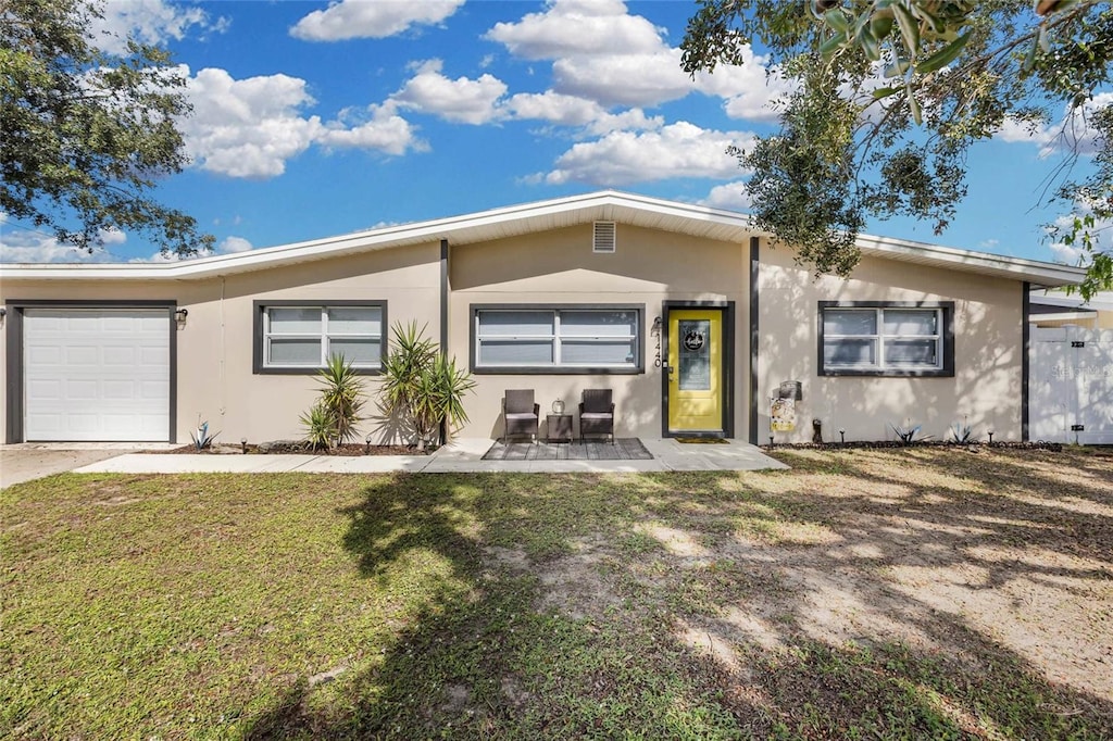 view of front of property featuring a front yard and a garage