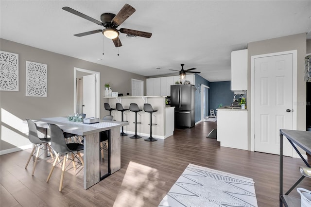 dining space with dark hardwood / wood-style floors and ceiling fan