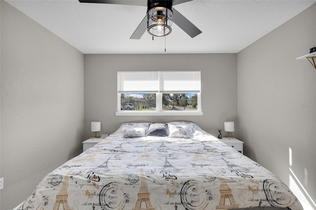 bedroom with ceiling fan and a textured ceiling