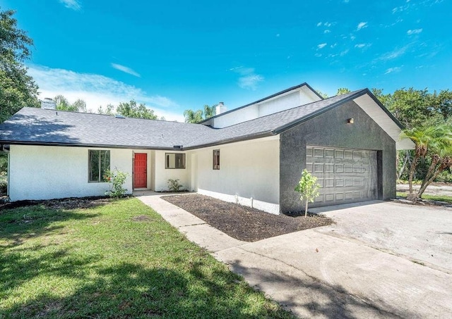 ranch-style house with a garage and a front lawn