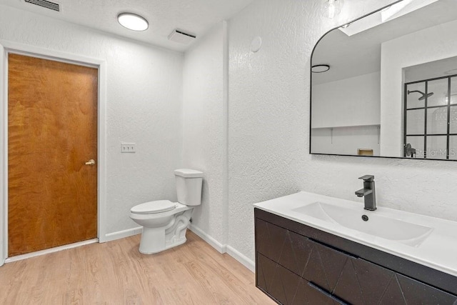 bathroom featuring vanity, wood-type flooring, and toilet