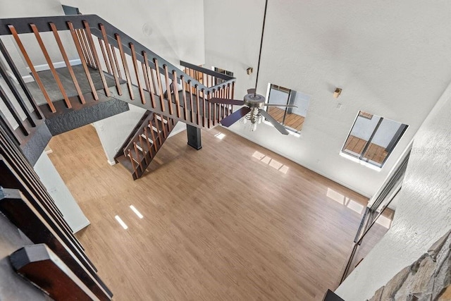 interior space featuring a high ceiling, ceiling fan, and hardwood / wood-style floors