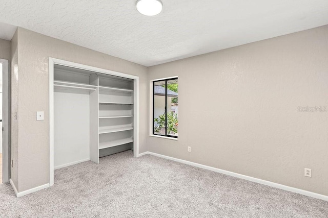 unfurnished bedroom with light carpet and a closet