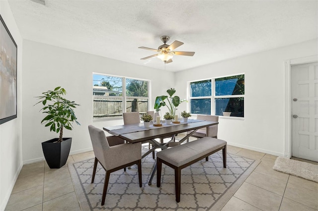 tiled dining room featuring a textured ceiling and ceiling fan