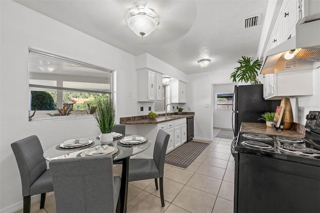 kitchen featuring light tile patterned floors, sink, white cabinetry, and black appliances