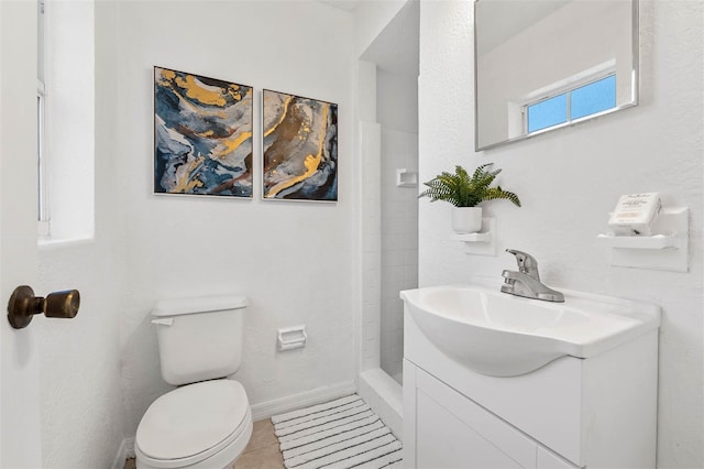 bathroom with tile patterned flooring, vanity, toilet, and walk in shower