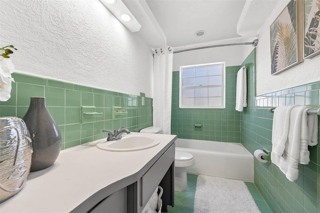 full bathroom featuring tile patterned floors, vanity, shower / tub combo with curtain, tile walls, and toilet