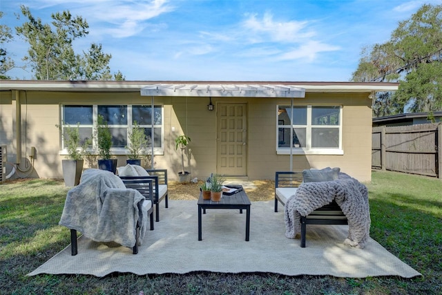 back of house with a lawn, an outdoor living space, and a patio area