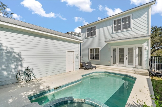 back of house with french doors, a patio area, and a swimming pool with hot tub