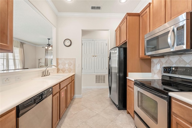 kitchen with backsplash, sink, ceiling fan, ornamental molding, and appliances with stainless steel finishes