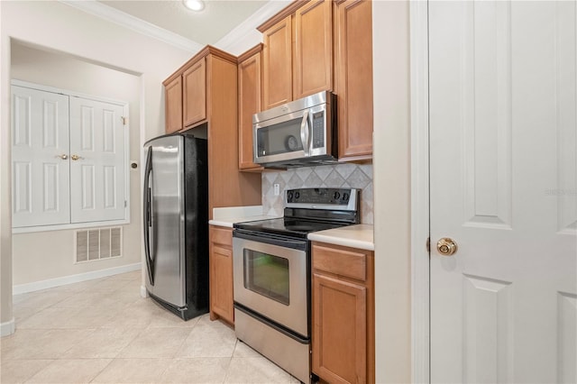 kitchen with backsplash, crown molding, light tile patterned floors, and stainless steel appliances