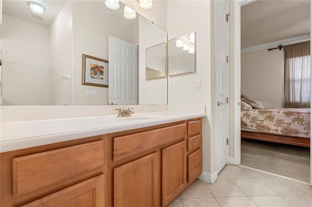 bathroom featuring tile patterned flooring, vanity, and crown molding