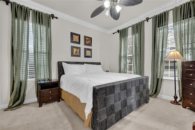 carpeted bedroom with multiple windows, ceiling fan, and ornamental molding