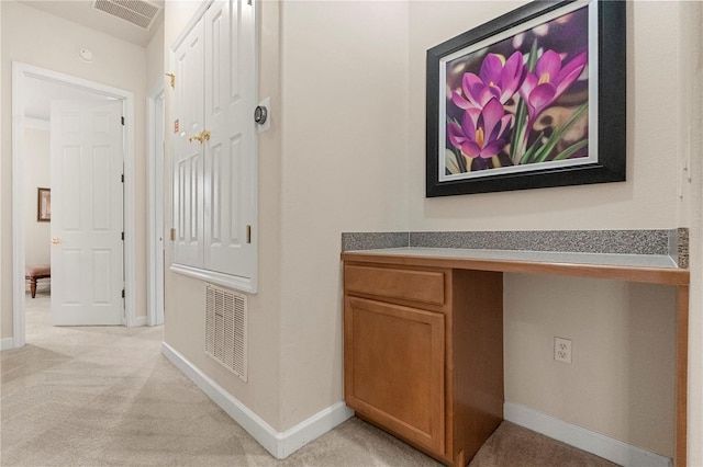 corridor featuring light colored carpet