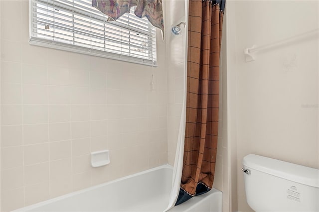 bathroom featuring shower / bath combination with curtain and toilet