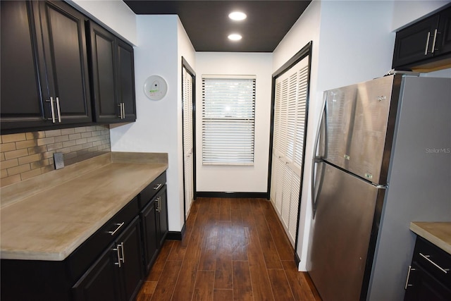 kitchen with stainless steel refrigerator, decorative backsplash, and dark hardwood / wood-style floors