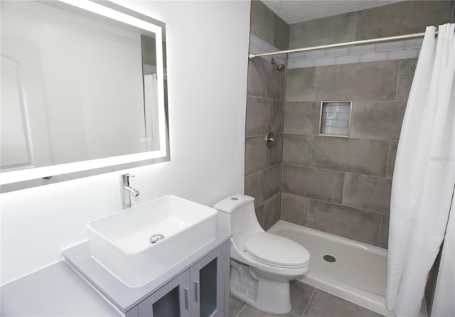 bathroom featuring toilet, vanity, tile patterned floors, and curtained shower