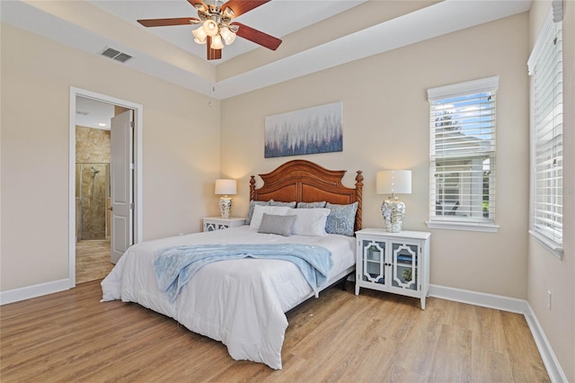 bedroom with ensuite bathroom, ceiling fan, and light hardwood / wood-style flooring