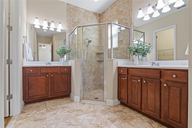 bathroom featuring ceiling fan, vanity, and a shower with shower door