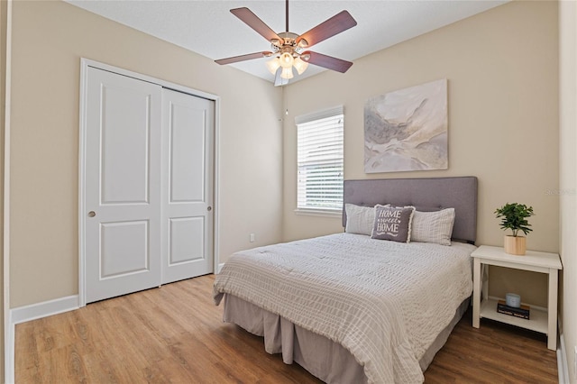 bedroom with a closet, hardwood / wood-style flooring, and ceiling fan