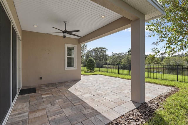 view of patio / terrace featuring ceiling fan and a water view