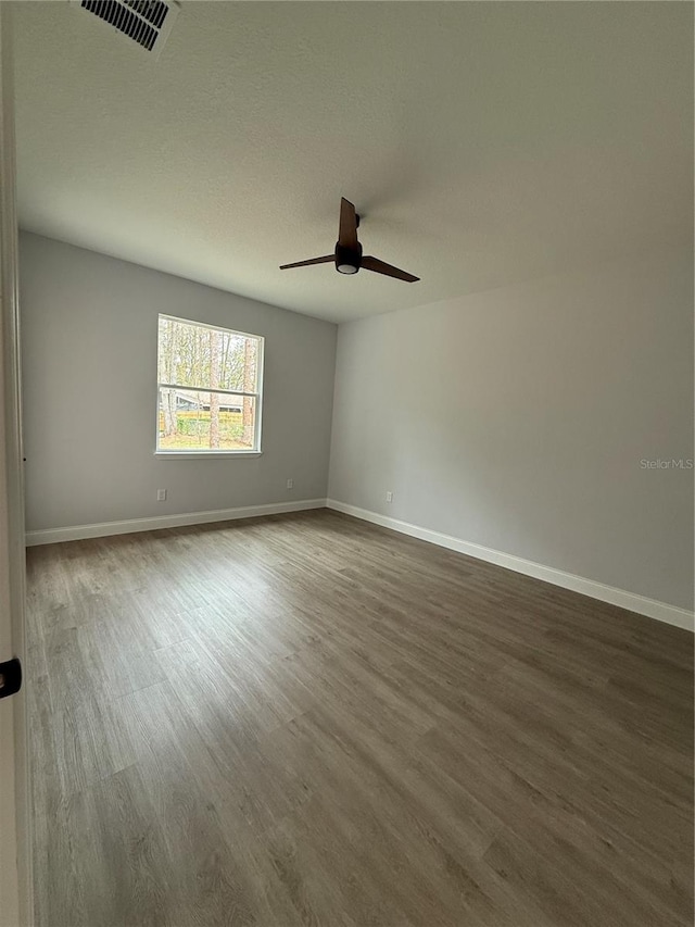 unfurnished room with ceiling fan and dark hardwood / wood-style flooring