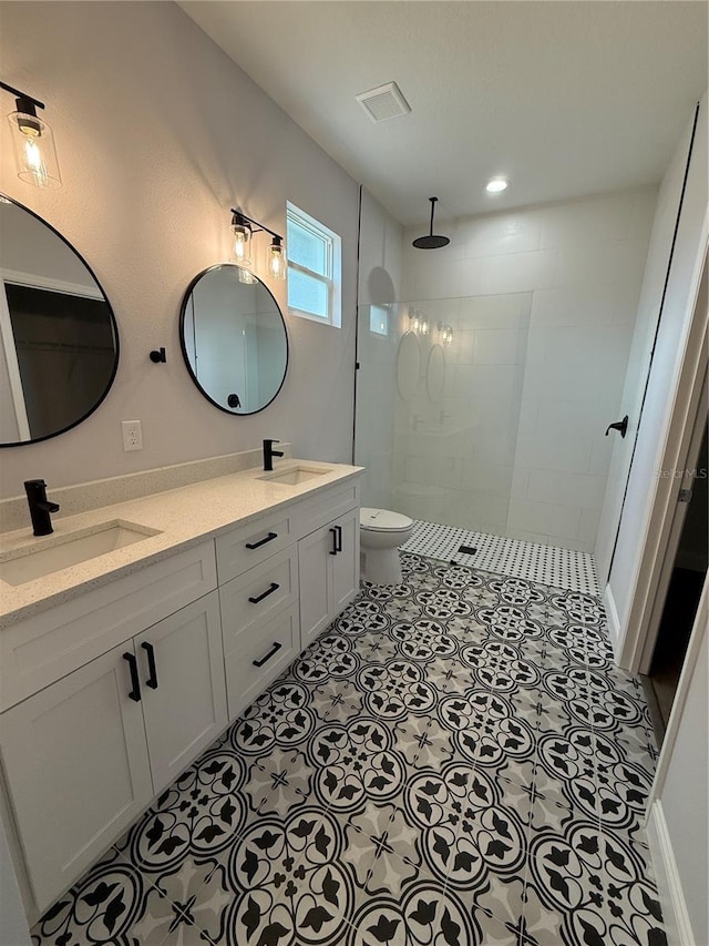 bathroom featuring tiled shower, vanity, and toilet