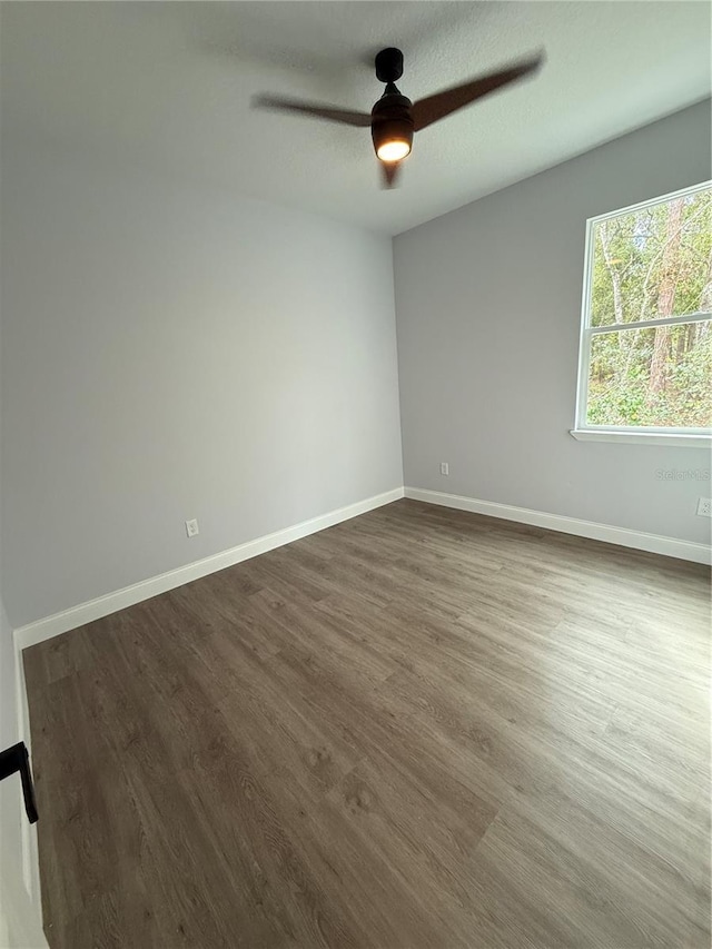 empty room featuring a textured ceiling, ceiling fan, and dark wood-type flooring