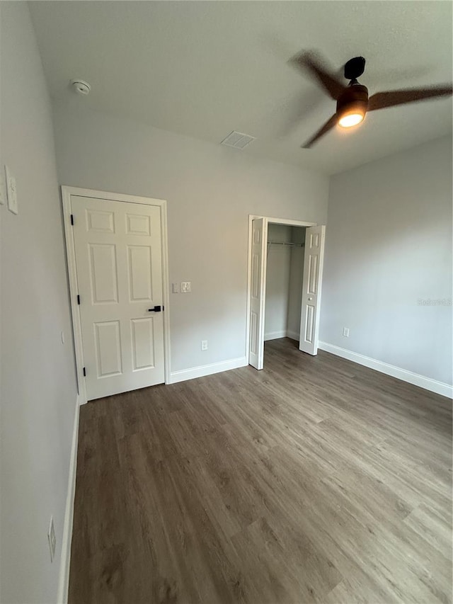 unfurnished bedroom featuring a closet, hardwood / wood-style flooring, and ceiling fan