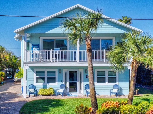 view of front facade featuring a front yard and a balcony