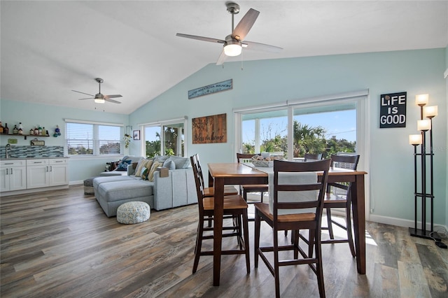 dining room with dark hardwood / wood-style flooring, vaulted ceiling, and ceiling fan