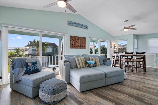 living room with ceiling fan, dark hardwood / wood-style flooring, and vaulted ceiling