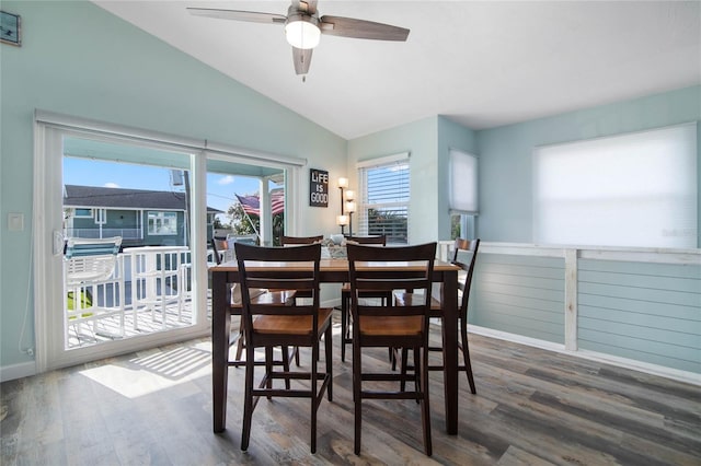 dining area with ceiling fan, dark hardwood / wood-style flooring, and vaulted ceiling