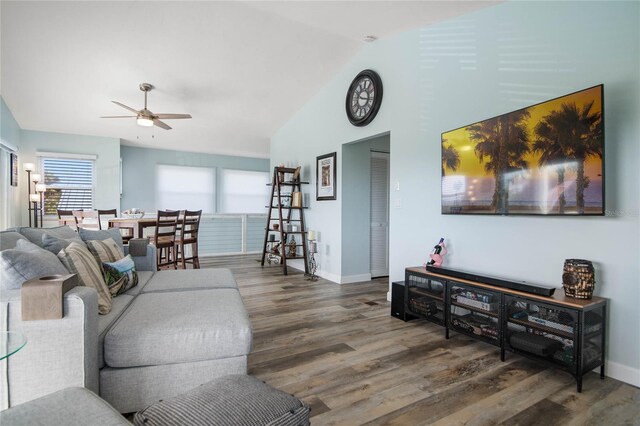 living room with ceiling fan, dark hardwood / wood-style floors, and vaulted ceiling