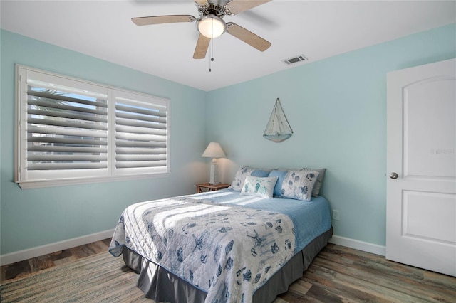 bedroom with ceiling fan and dark wood-type flooring