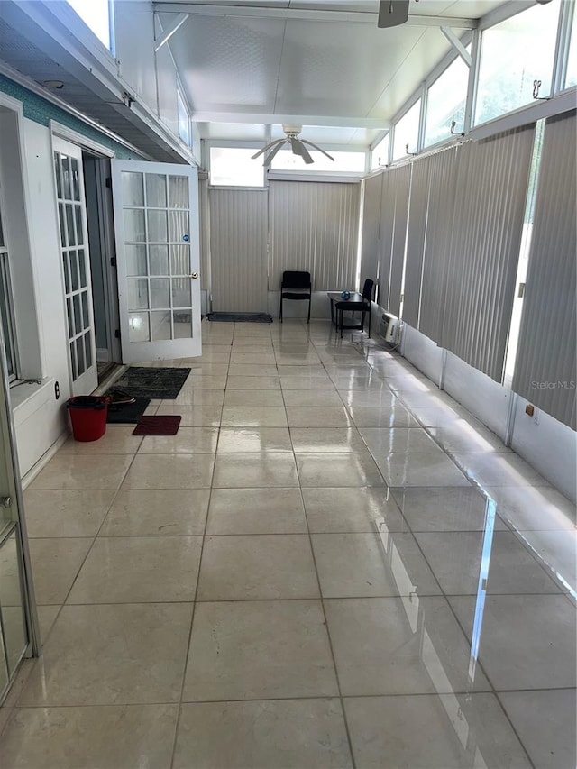 unfurnished sunroom with ceiling fan and lofted ceiling