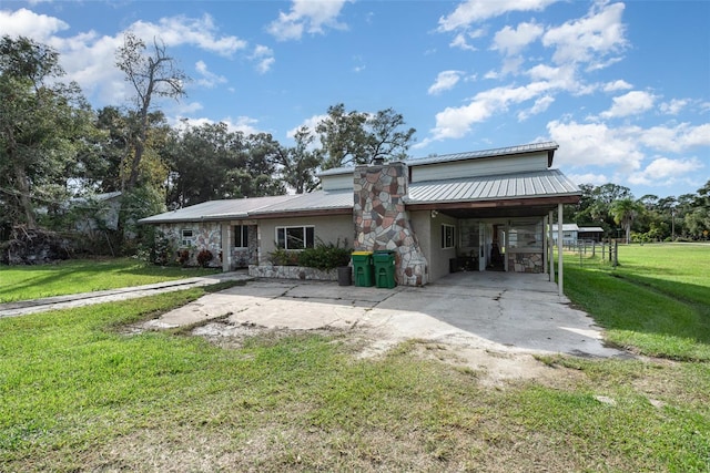 rear view of house with a carport and a yard