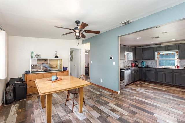 dining space featuring dark hardwood / wood-style floors, ceiling fan, and sink