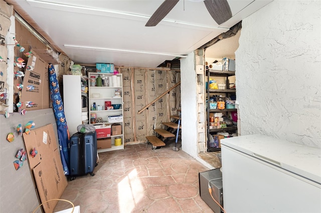 basement with white refrigerator and ceiling fan