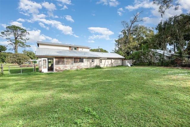 rear view of property with a lawn