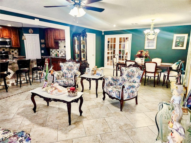 living room featuring crown molding, french doors, and ceiling fan with notable chandelier