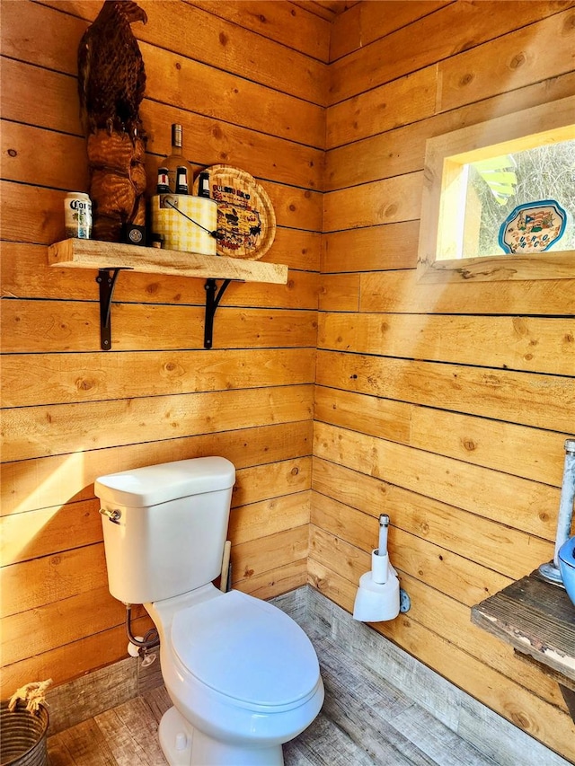 bathroom with wood walls, toilet, and hardwood / wood-style flooring