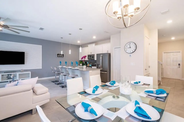 dining space with light tile patterned floors and ceiling fan with notable chandelier