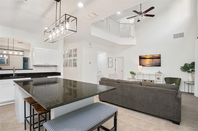 kitchen featuring white cabinetry, decorative light fixtures, and a high ceiling