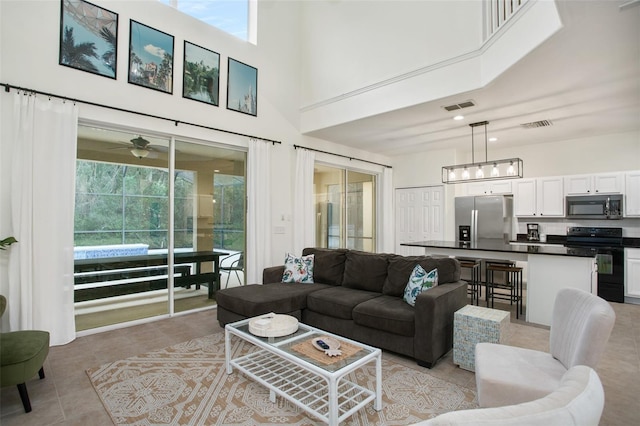 living room with light tile patterned floors and a towering ceiling