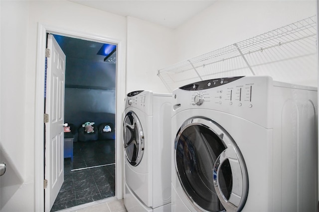 washroom with separate washer and dryer and light tile patterned floors