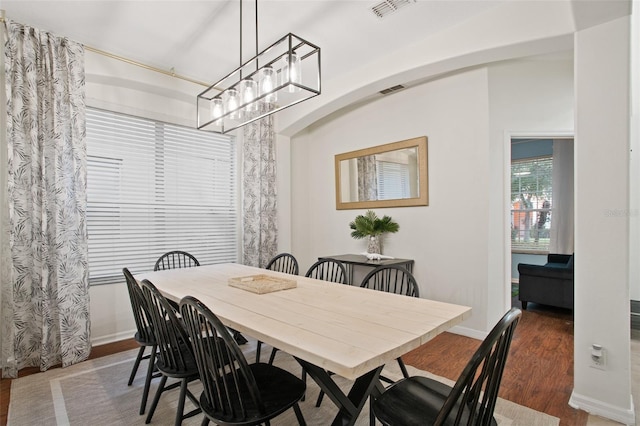 dining room featuring dark hardwood / wood-style flooring and a notable chandelier