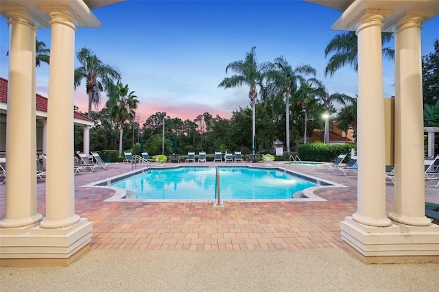 pool at dusk with a patio